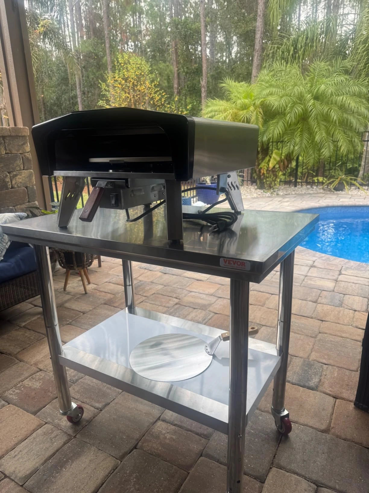 SizzleDelite Firo 14 pizza oven baking pizza in a garage setup